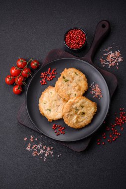Lezzetli kızarmış balık pirzolası ya da koyu beton arka planda tuzlu, baharatlı ve otlu köfte.
