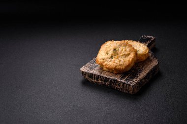 Lezzetli kızarmış balık pirzolası ya da koyu beton arka planda tuzlu, baharatlı ve otlu köfte.