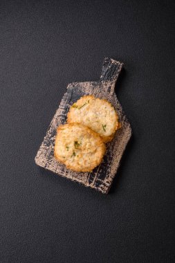 Lezzetli kızarmış balık pirzolası ya da koyu beton arka planda tuzlu, baharatlı ve otlu köfte.