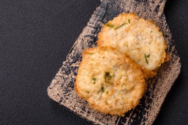 Lezzetli kızarmış balık pirzolası ya da koyu beton arka planda tuzlu, baharatlı ve otlu köfte.