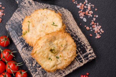 Lezzetli kızarmış balık pirzolası ya da koyu beton arka planda tuzlu, baharatlı ve otlu köfte.