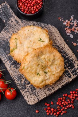 Lezzetli kızarmış balık pirzolası ya da koyu beton arka planda tuzlu, baharatlı ve otlu köfte.