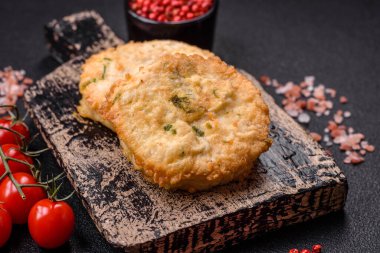 Lezzetli kızarmış balık pirzolası ya da koyu beton arka planda tuzlu, baharatlı ve otlu köfte.