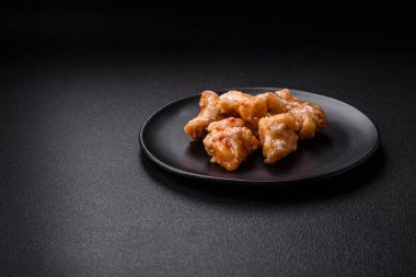 Tatlı ve ekşi soslu lezzetli ızgara tavuk parçaları seramik tabakta tuz ve baharat.