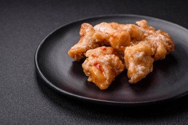 Tatlı ve ekşi soslu lezzetli ızgara tavuk parçaları seramik tabakta tuz ve baharat.