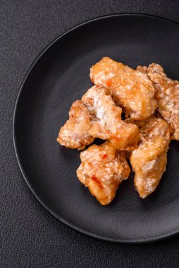 Tatlı ve ekşi soslu lezzetli ızgara tavuk parçaları seramik tabakta tuz ve baharat.