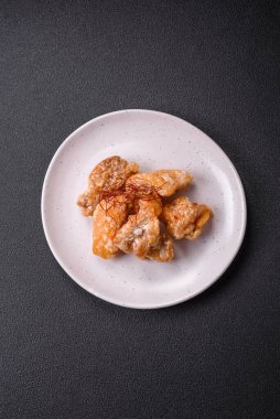 Tatlı ve ekşi soslu lezzetli ızgara tavuk parçaları seramik tabakta tuz ve baharat.