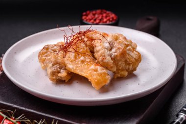 Tatlı ve ekşi soslu lezzetli ızgara tavuk parçaları seramik tabakta tuz ve baharat.