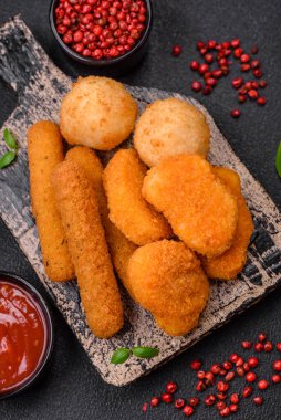 Lezzetli nuggetlar, çubuklar ve mozzarella topları ve tuzlu ve baharatlı parmesan peyniri. Fast food, sağlıksız yemek
