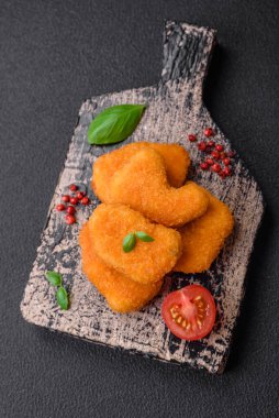 Delicious fresh crispy chicken nuggets on a dark concrete background. Unhealthy food, fast food