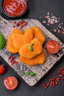 Delicious fresh crispy chicken nuggets on a dark concrete background. Unhealthy food, fast food