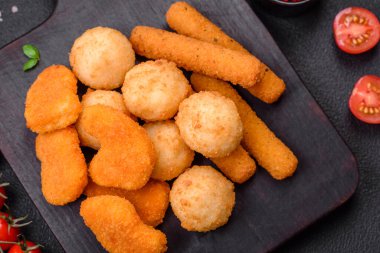 Lezzetli nuggetlar, çubuklar ve mozzarella topları ve tuzlu ve baharatlı parmesan peyniri. Fast food, sağlıksız yemek