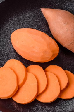 Koyu arkaplanda domates ve baharatlı taze, büyük, pembe patates şişeleri. Sağlıklı bir vejetaryen yemeği pişirmek.