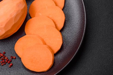 Koyu arkaplanda domates ve baharatlı taze, büyük, pembe patates şişeleri. Sağlıklı bir vejetaryen yemeği pişirmek.