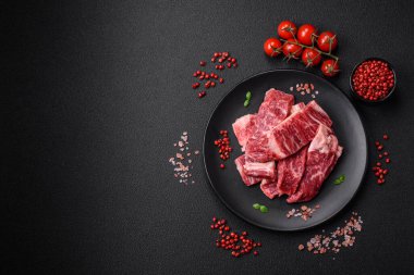 Koyu beton zeminde tuzlu ve baharatlı taze çiğ et dilimleri.