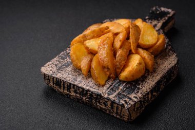 Tuzlu, baharatlı ve çimento kaplı lezzetli kızarmış patates dilimleri.