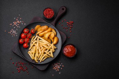 Koyu beton zeminde tuzlu ve baharatlı taze kızarmış patates kızartması.