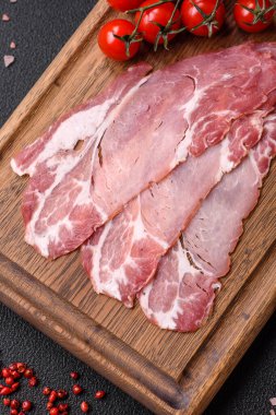 Lezzetli füme jamon dilimleri ya da koyu beton arka planda tuzlu, baharatlı ve otlu jambon.