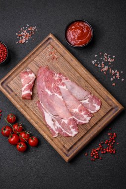 Lezzetli füme jamon dilimleri ya da koyu beton arka planda tuzlu, baharatlı ve otlu jambon.