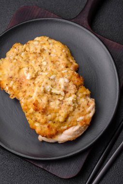 Dijon hardalıyla kızartılmış lezzetli et. Tuz, baharat ve otlarla birlikte koyu beton bir arka planda.