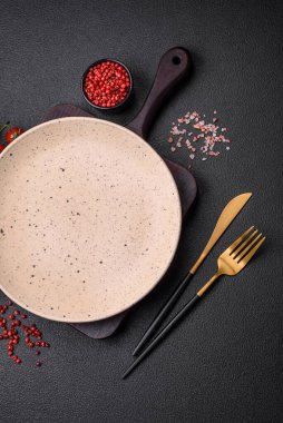 Koyu dokulu arka planda boş seramik tabak. Aile yemeği için mutfak gereçleri hazırlıyorum.