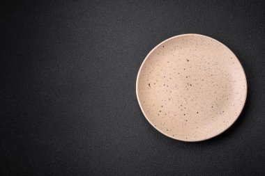 Koyu dokulu arka planda boş seramik tabak. Aile yemeği için mutfak gereçleri hazırlıyorum.