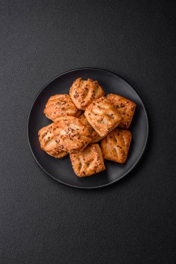 Sosisli çıtır çıtır mini puflar ya da koyu beton arka planda tuzlu et, kekik ve susam.