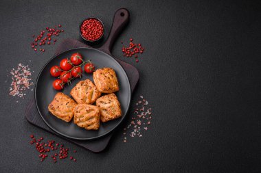 Sosisli çıtır çıtır mini puflar ya da koyu beton arka planda tuzlu et, kekik ve susam.