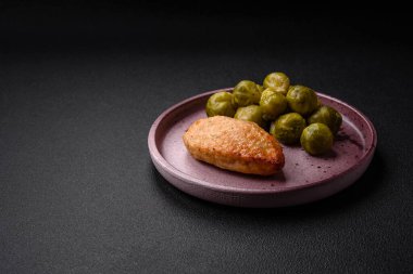 Lezzetli taze kızarmış vejetaryen soya pirzolası, tuzlu, baharatlı ve sebzeli, koyu beton bir zeminde seramik bir tabakta.