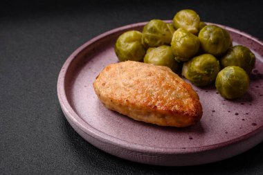 Lezzetli taze kızarmış vejetaryen soya pirzolası, tuzlu, baharatlı ve sebzeli, koyu beton bir zeminde seramik bir tabakta.