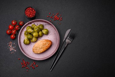 Lezzetli taze kızarmış vejetaryen soya pirzolası, tuzlu, baharatlı ve sebzeli, koyu beton bir zeminde seramik bir tabakta.