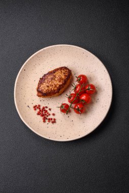 Lezzetli taze kızarmış vejetaryen soya pirzolası, tuzlu, baharatlı ve sebzeli, koyu beton bir zeminde seramik bir tabakta.