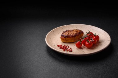 Lezzetli taze kızarmış vejetaryen soya pirzolası, tuzlu, baharatlı ve sebzeli, koyu beton bir zeminde seramik bir tabakta.