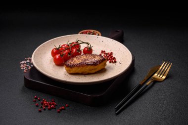 Lezzetli taze kızarmış vejetaryen soya pirzolası, tuzlu, baharatlı ve sebzeli, koyu beton bir zeminde seramik bir tabakta.