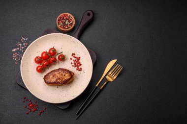 Lezzetli taze kızarmış vejetaryen soya pirzolası, tuzlu, baharatlı ve sebzeli, koyu beton bir zeminde seramik bir tabakta.