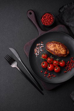 Lezzetli taze kızarmış vejetaryen soya pirzolası, tuzlu, baharatlı ve sebzeli, koyu beton bir zeminde seramik bir tabakta.