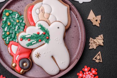 Taze lezzetli fırınlanmış Noel ya da koyu beton arka planda parlak renk temalı zencefilli kurabiyeler.