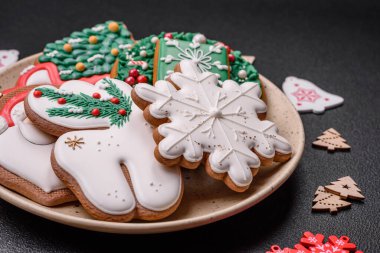 Taze lezzetli fırınlanmış Noel ya da koyu beton arka planda parlak renk temalı zencefilli kurabiyeler.