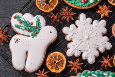 Taze lezzetli fırınlanmış Noel ya da koyu beton arka planda parlak renk temalı zencefilli kurabiyeler.