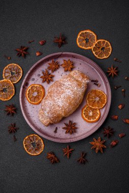 Koyu beton arka planda seramik tabakta çikolata kremalı lezzetli çıtır kruvasanlar.