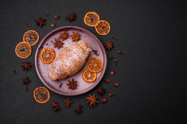 Koyu beton arka planda seramik tabakta çikolata kremalı lezzetli çıtır kruvasanlar.