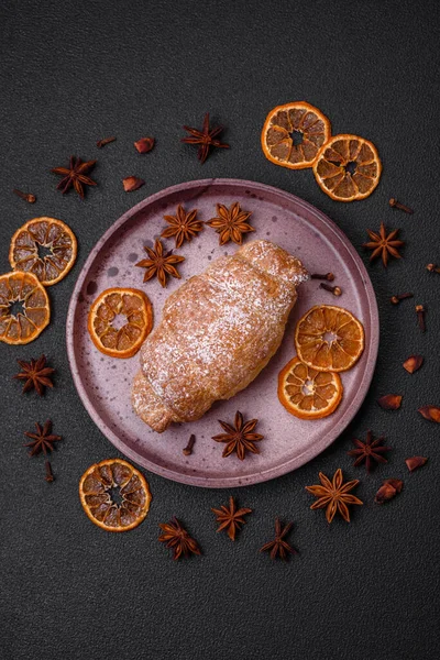 Koyu beton arka planda seramik tabakta çikolata kremalı lezzetli çıtır kruvasanlar.