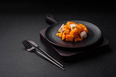 Lezzetli sulu salata dilimlenmiş kabak peyniriyle, baharatla ve susam tohumuyla seramik tabakta.