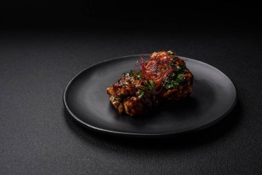 Tuz, baharat, otlar ve seramik tabakta susam tohumlarıyla teriyaki soslu lezzetli kızarmış tavuk.