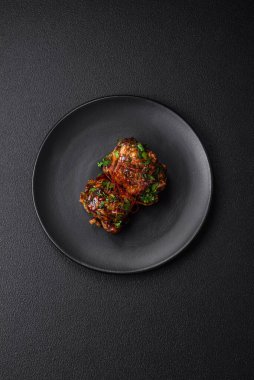 Tuz, baharat, otlar ve seramik tabakta susam tohumlarıyla teriyaki soslu lezzetli kızarmış tavuk.