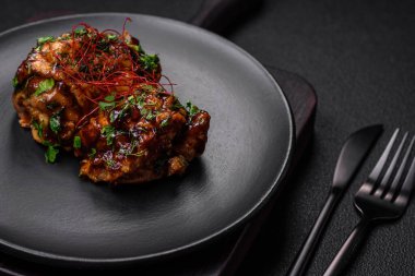 Tuz, baharat, otlar ve seramik tabakta susam tohumlarıyla teriyaki soslu lezzetli kızarmış tavuk.