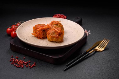 Lezzetli taze köfteler kıyma ya da domates soslu balık, havuç, soğan, tuz ve baharatlar koyu beton arka planda.