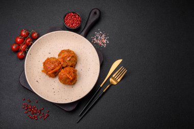 Lezzetli taze köfteler kıyma ya da domates soslu balık, havuç, soğan, tuz ve baharatlar koyu beton arka planda.