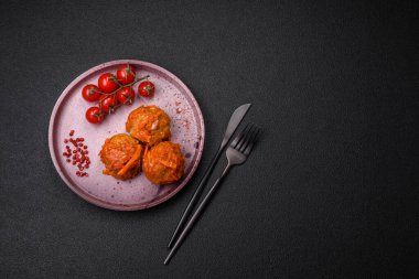 Lezzetli taze köfteler kıyma ya da domates soslu balık, havuç, soğan, tuz ve baharatlar koyu beton arka planda.