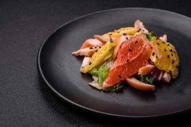 Lezzetli taze salata dilimlenmiş tavuk, greyfurt, marul, zeytinyağlı susam ve çimento kaplı seramik bir tabakta